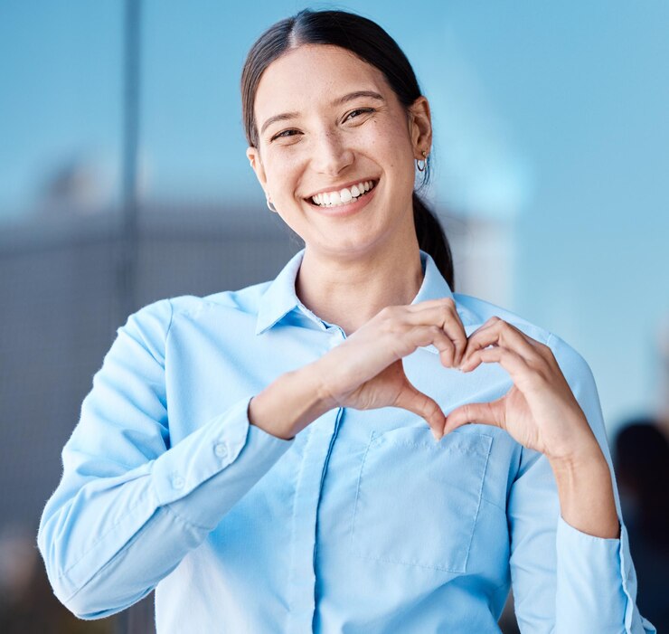 Smiling woman making a heart shape with her hands